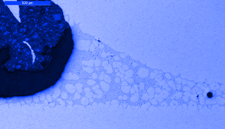 Obraz mikroskopowy przekroju połączenia lutowanego niebieskie tło